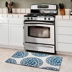 a silver stove top oven sitting inside of a kitchen next to white counter tops and cabinets