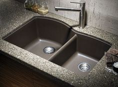 an image of a kitchen sink with granite counter top and brown color finish on it