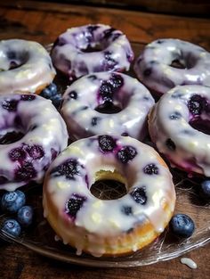 blueberry donuts with white glaze on a glass plate