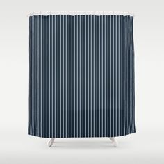 a shower curtain with blue and white stripes on the outside, in front of a gray background