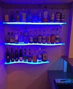 a shelf filled with lots of bottles of liquor next to a wall mounted bar top