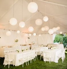 a large tent with tables and chairs set up in the grass for a wedding reception