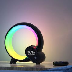 a colorful light sitting on top of a wooden table next to a remote control controller