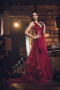 a woman in a red dress posing for the camera with her hands on her hips