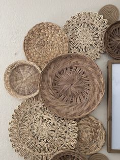 woven baskets are arranged on the wall next to a mirror