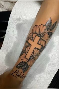 a person with a cross tattoo on their arm