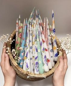 a basket filled with lots of different colored candles