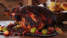 a large piece of meat sitting on top of a table next to fruit and bread