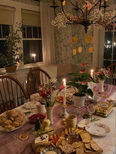 a dining room table is set with food and candles