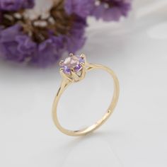 Romantic, purple amethyst ring in 14k yellow gold, dainty real gold solitaire engagement or promise ring for women.   This beautiful handmade ring is made of solid 14k yellow gold and is set with a round-faceted amethyst. The gemstone is based on a crown-like that gives this ring a regal design that cannot be ignored.   Amethyst is February's birthstone.  This ring can be an alternative engagement/promise/wedding ring or a gift for a special occasion.  This handmade gold ring is carefully handcr Fine Jewelry 14k Gold Amethyst Ring With Round Cut, Purple Sapphire Ring With 14k Gold Prong Setting, Purple Amethyst Ring With Prong Setting In 14k Gold, Yellow Gold Amethyst Ring With Accent Stones, Round Cut, Yellow Gold Amethyst Ring With Round Cut Accent Stones, Purple 14k Gold Fine Jewelry Rings, Amethyst Center Stone Birthstone Ring In Yellow Gold, 14k Gold Ring With Purple Center Stone, Yellow Gold Birthstone Ring With Amethyst Center Stone