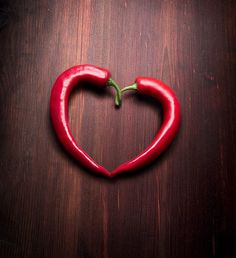 a heart shaped chili pepper with the words in love written on it's side