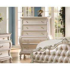 a white bed sitting in a bedroom next to a dresser with drawers on top of it