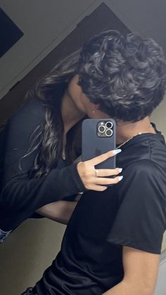 a man and woman taking a selfie in front of a mirror with their cell phone