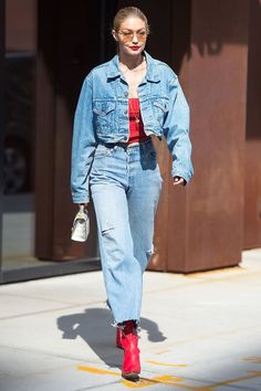 a woman wearing red shoes and jeans is walking down the street