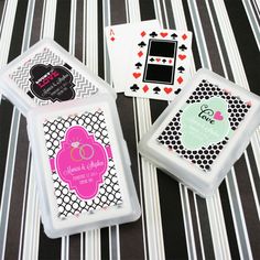 four playing cards are sitting on a striped tablecloth with black, white and pink designs