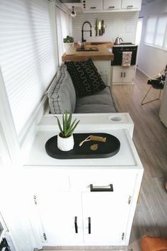 a small living room with a couch and kitchen in the background