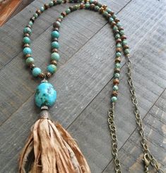 "This is a unique and trendy necklace made with beautiful beads and Sari Silk! One of a kind! I made the tassel from Sari Silk ribbon in a rich goldish brown tone.  The tassel has an antique bronze cap with rhinestone rondelles, and is attached to a gorgeous chunk of natural turquoise. The necklace itself is made from 8mm natural turquoise beads, tiger eye rondelles, bronze faceted crystal beads, and picasso turquoise czech glass beads. Antique bronze daisy spacers accent the necklace.  Antique bronze chain finishes out the necklace with a lobster claw clasp, that make the necklace adjustable. This is a long necklace, perfect for layering.  The finished length is about 36\".  The turquoise chunk and silk tassel unit is about 5.5 inches long." Bohemian Brown Lariat Beaded Necklaces, Bohemian Long Tassel Necklace With Dangling Beads, Bohemian Brown Hand-strung Beaded Necklaces, Bohemian Long Tassel Necklace With Fringe, Bohemian Long Fringe Tassel Necklace, Brown Tassel Necklace For Festival, Bohemian Brown Hand-strung Beaded Necklace, Bohemian Long Tassel Fringe Necklace, Brown Bohemian Tassel Necklace