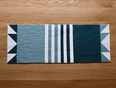 a blue and white rug sitting on top of a wooden floor