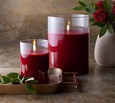 two red candles sitting next to each other on a table