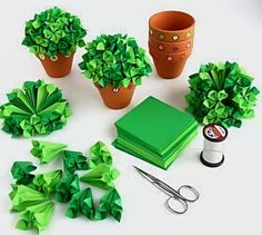 green paper flowers, scissors and other crafting supplies laid out on a white surface