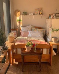 a bed room with a neatly made bed and some plants on the nightstands next to it