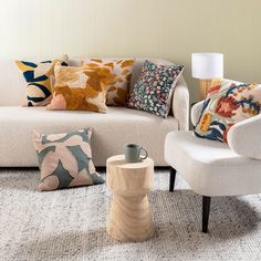 a living room filled with white furniture and colorful pillows on top of it's covers