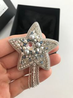 a person holding a star brooch in their hand