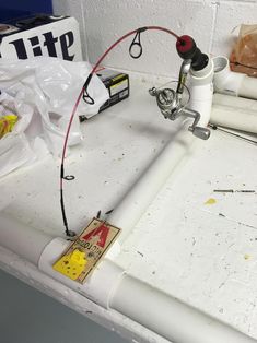 a white sink with a faucet and some wires attached to the faucet