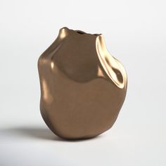 a gold vase sitting on top of a white table