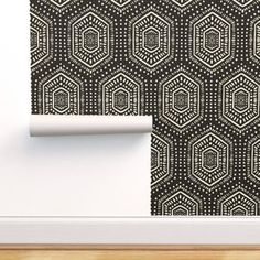 a black and white wallpaper with an intricate design on it's side, next to a door