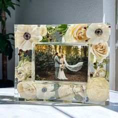 a wedding photo frame with flowers on it