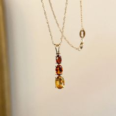 14K yellow gold graduating citrine + Madeira citrine pendant. Simply slide this pendant onto a yellow gold chain to complete the look! Chain not included Weight: .86g Tapered bail Pendant measures: 18mm x 5.2mm Chain passage dimensions: 4.7mm x 3.5mm (1) .21 CT TW oval Madeira citrine; 5mm x 3mm (1) .40 CT TW oval citrine; 6mm x 4mm (1) .70 CT TW oval citrine; 7mm x 5mm November Baby, Faberge Jewelry, Saint Jewelry, Citrine Jewelry, Citrine Pendant, Citrine Necklace, Citrine Gemstone, Yellow Gold Chain, Cross Charms