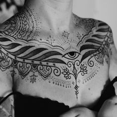 black and white photograph of a woman with tattoos on her chest, holding two apples