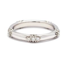 a white gold ring with three diamonds on the top and bottom, set in 18k white gold