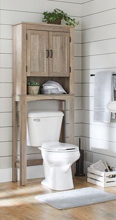 a white toilet sitting next to a wooden cabinet