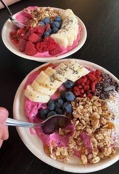 two white plates topped with fruit and granola