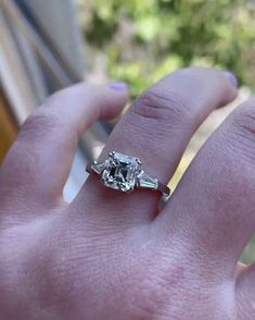 a woman's hand with a ring on it and a diamond in the middle