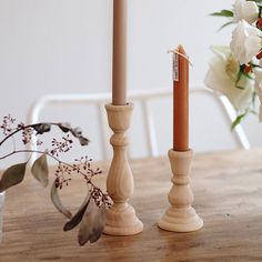 two candles sitting on top of a wooden table