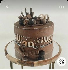 a chocolate cake sitting on top of a metal stand