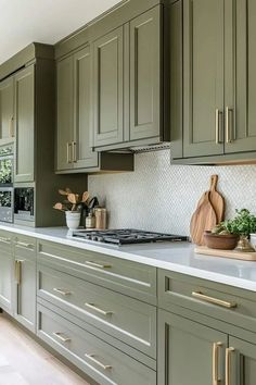 a kitchen with green cabinets and white counter tops