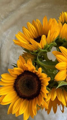 a vase filled with lots of yellow sunflowers