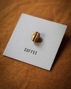 a small gold ring sitting on top of a white piece of paper with the word coffee printed on it