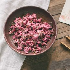 a bowl filled with meat sitting on top of a table next to chopsticks