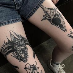 a woman's legs with tattoos on them and an image of a dragon in the middle