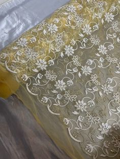 a yellow and white table cloth on top of a plastic bag covered in sheer fabric