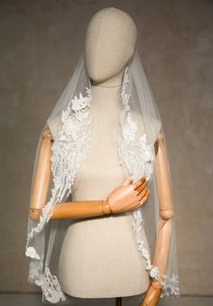 a mannequin wearing a white veil with flowers on it