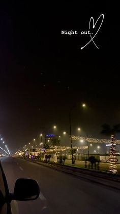 night out with lights on the street and cars driving down the road in front of them