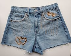 Bling Denim, Vintage Style, 90's High Waist shorts! Look cute in these custom bling denim cut off shorts.  Purchased new and embellished with silver, crystal tassel fringe on the front pockets.  Leopard heart iron on patches with rhinestones on the front left pocket and lower left thigh.  Cute leopard iron on heart bows on the back pockets. Leopard patches have a furry textured feel to them.  These can be customized with different embellishments, and short styles.  I'll be making more production soon!   Hand wash Spot clean Lay flat to dry Iron if necessary, avoiding embellishments Bedazzled Denim, Denim Fringe Shorts, Style 90's, Bling Denim, Denim Fringe, Fringe Shorts, Tassel Shorts, Bling Jeans, Custom Bling