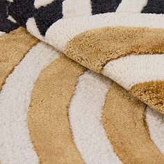 an area rug with various colors and patterns on the floor, including black, white, yellow and brown