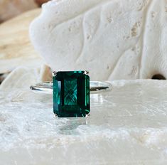 This classic 4 prong setting contains a beautiful 4.00ct. lab created emerald cut emerald. The emerald cut stone measures approximately 10x8mm. The ring is available in sterling silver, and 14k white, yellow, or rose gold. This ring makes a great promise or engagement ring. Emerald is the birthstone for May. Please send me a message if you need a size not listed. * This ring can be customized with any color center stone. All items are handmade by me in my shop in Woodbridge, NJ. Please message m Radiant Cut Emerald Ring With Center Stone, Emerald Cut Emerald Ring With Center Stone, Solitaire Emerald Ring With Radiant Cut, Radiant Cut Solitaire Emerald Ring, Emerald Ring With Radiant Cut And Accent Stones, Square Cut Center Stone Emerald Ring, Baguette Cut Solitaire Emerald Ring, Emerald Cut Birthstone Emerald Ring, Green Emerald Solitaire Ring In Radiant Cut